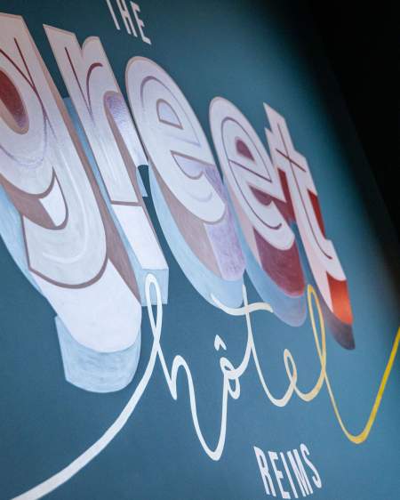 Logo greet hotel sur le mur de la réception