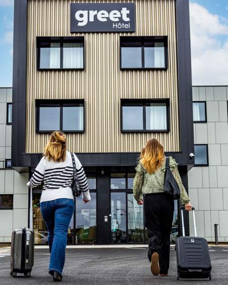 Vue extérieur de l'hôtel avec deux jeunes femmes devant l'entrée