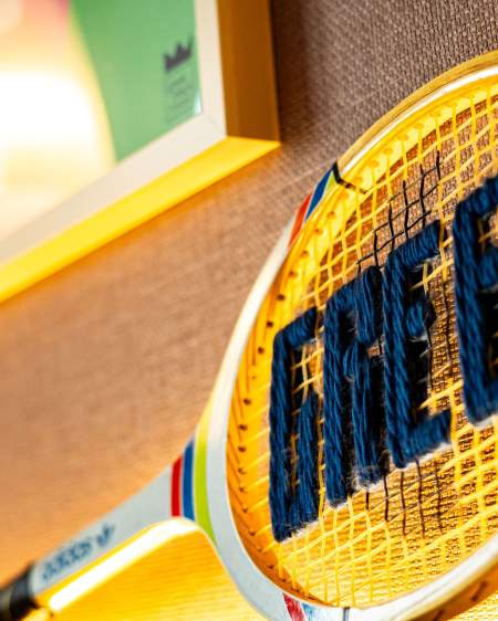 Raquette de tennis avec l'inscription Greet